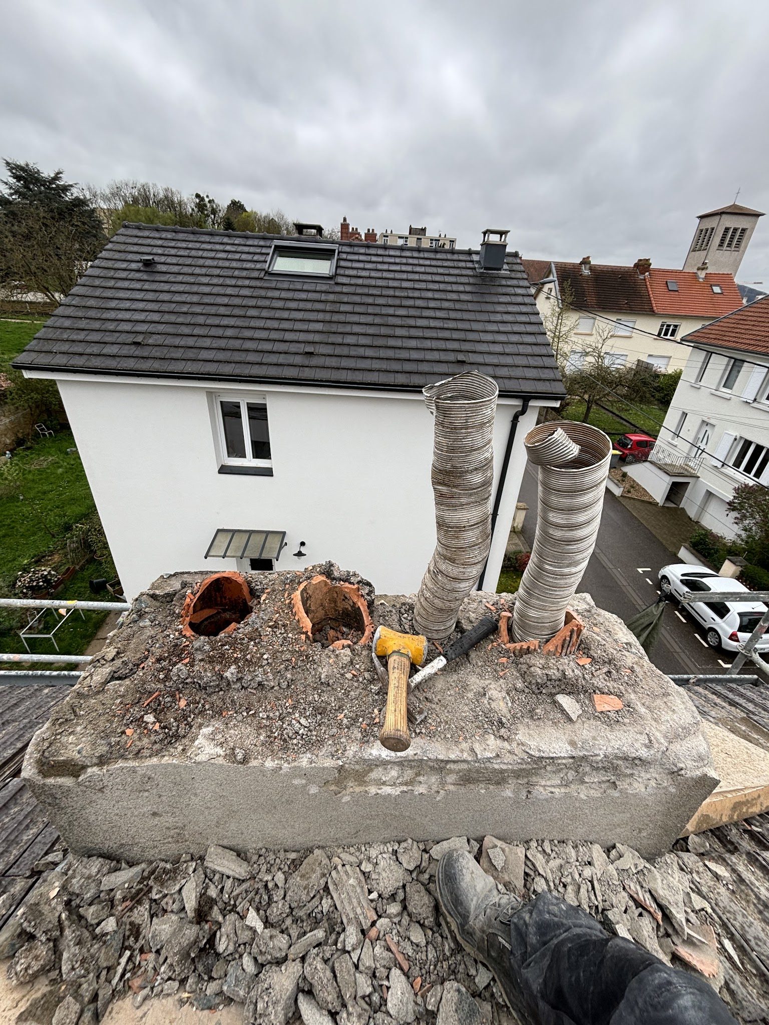 Souche de cheminée ouverte sur le toit, deux conduits souples neufs et une massette
